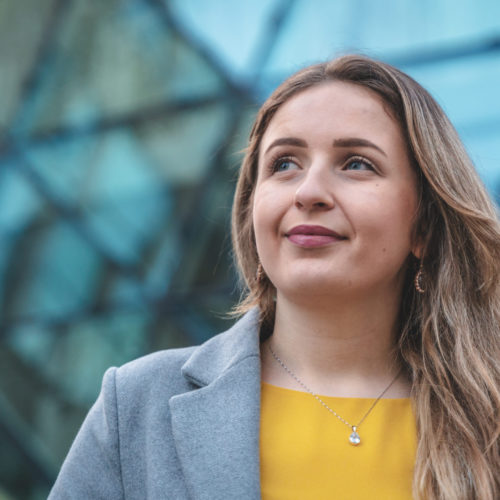 Portrait of a beautiful young woman in a yellow shirt and a gray jacket