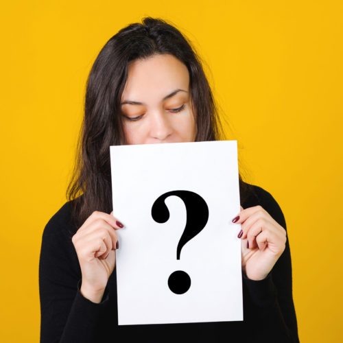 Question mark, symbol. Cute girl holding a question mark over yellow background. Card with question mark symbol. Women questions. Getting answers, thinking.